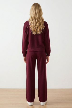 Completo tuta donna composto da felpa girocollo a maniche lunghe con spalla scesa, con dettaglio patch sulla manica, e pantalone a gamba dritta. Il pantalone ha elastico in vita, coulisse regolabile a contrasto e pratiche tasche laterali.
