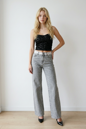 Jeans donna palazzo in denim grigio effetto slavato. La vita alta valorizza la silhouette, mentre la gamba ampia e dritta slancia la figura. Il pizzo lungo il punto vita, aggiunge un elemento femminile e ricercato.
