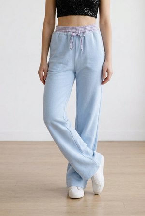 Pantalone palazzo con vita elasticizzata in fantasia scozzese. Il cordino regolabile richiama il motivo della cintura elasticizzata. La gamba ampia slancia la figura.