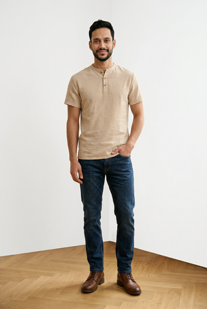 T-shirt beige uomo, con chiusura frontale con 3 bottoni a contrasto e girocollo con apertura. Sul fondo, a sinistra, una piccola targhetta decorativa in legno.
