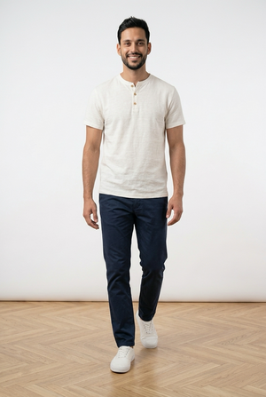T-shirt bianca uomo, con chiusura frontale con 3 bottoni a contrasto e girocollo con apertura. Sul fondo, a sinistra, una piccola targhetta decorativa in legno.