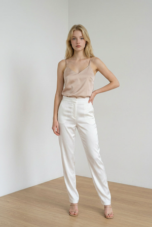 Top beige realizzato con tessuto morbido; spalline sottili e regolabili, ampio scollo a V che valorizza il décolleté