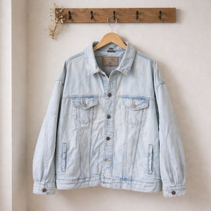 Giubbino denim uomo oversize con spalle leggermente scese, chiusura con bottoni frontali e tasche sul petto e laterali, su gruccia