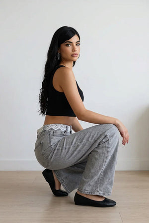 Jeans donna palazzo in denim grigio effetto slavato con vita alta, pizzo decorativo lungo il punto vita e tasche frontali e posteriori