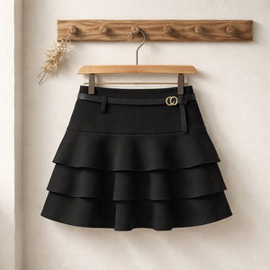 Gonna corta a balze con pantaloncino interno, vita alta elastica e cintura sottile con fibbia ad anelli metallici, su gruccia