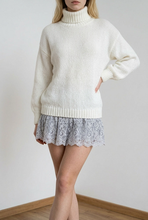 Vestito realizzato in morbida maglia calda, con maniche lunghe e ampio collo avvolgente con lavorazione a costine, coordinato al fondo a costine. Dettaglio la balza inferiore in pizzo.