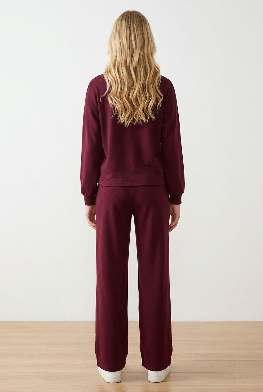 Completo tuta donna composto da felpa girocollo a maniche lunghe con spalla scesa, con dettaglio patch sulla manica, e pantalone a gamba dritta. Il pantalone ha elastico in vita, coulisse regolabile a contrasto e pratiche tasche laterali.