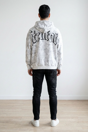 Felpa con cappuccio realizzata in tessuto morbido con effetto lavaggio marmorizzato. La felpa presenta chiusura frontale con zip, il cappuccio regolabile con coulisse, tasche laterali e stampa grafica a contrasto sul fronte e sul retro.
