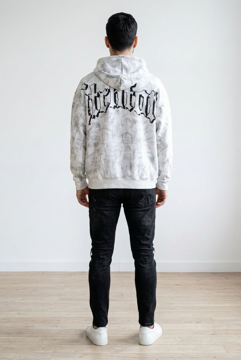 Felpa con cappuccio realizzata in tessuto morbido con effetto lavaggio marmorizzato. La felpa presenta chiusura frontale con zip, il cappuccio regolabile con coulisse, tasche laterali e stampa grafica a contrasto sul fronte e sul retro.