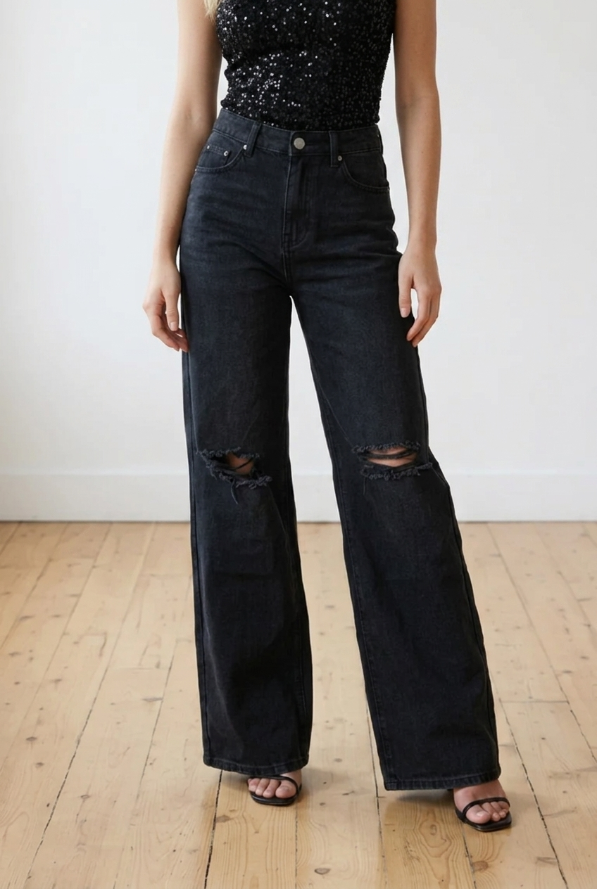 Jeans palazzo nero con strappi sulle ginocchia, modello high-waist