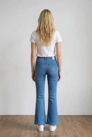 Jeans flare in denim chiaro, modello high-waist che valorizza il punto vita e slancia la figura. Questo capo d'abbigliamento segue la linea dei fianchi per poi aprirsi in una gamba a zampa, creando un effetto sinuoso ed elegante; il tessuto è impreziosito da micro applicazioni brillanti effetto sparkling distribuite su tutta la parte frontale.
