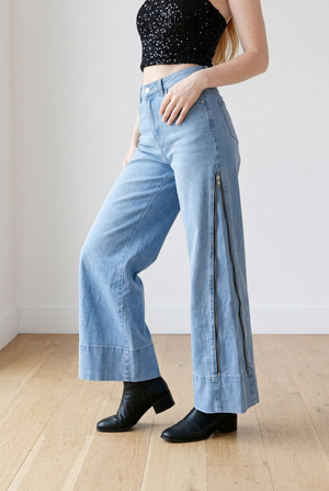 Jeans a palazzo in denim chiaro, modello high-waist, dettaglio la  zip laterale lungo la gamba 