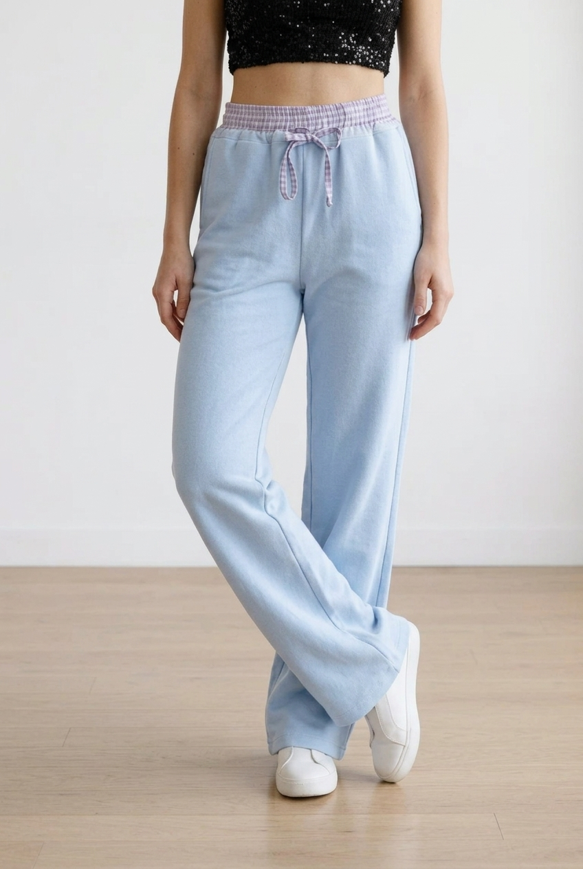 Pantalone palazzo con vita  elasticizzata in fantasia scozzese. Il cordino regolabile richiama il motivo della cintura elasticizzata. La gamba ampia slancia la figura.