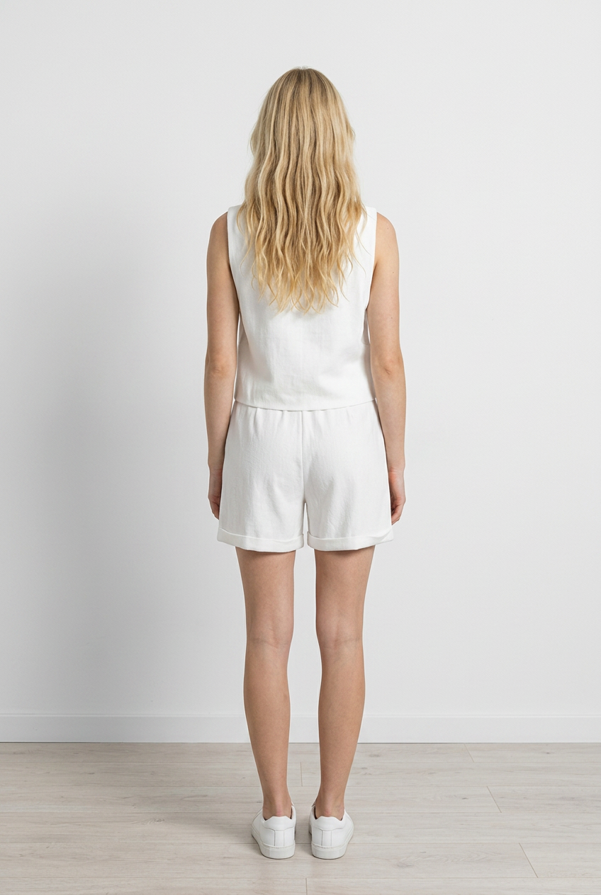 coordinato composto da gilet senza maniche con scollo a V e abbottonatura centrale, abbinato a shorts a vita alta  con pinces e risvolto in fondo. 