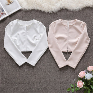 Giacca cropped beige e bianca senza colletto in ecopelle indossata, vestibilità cota e struttura minimal, vista frontale
