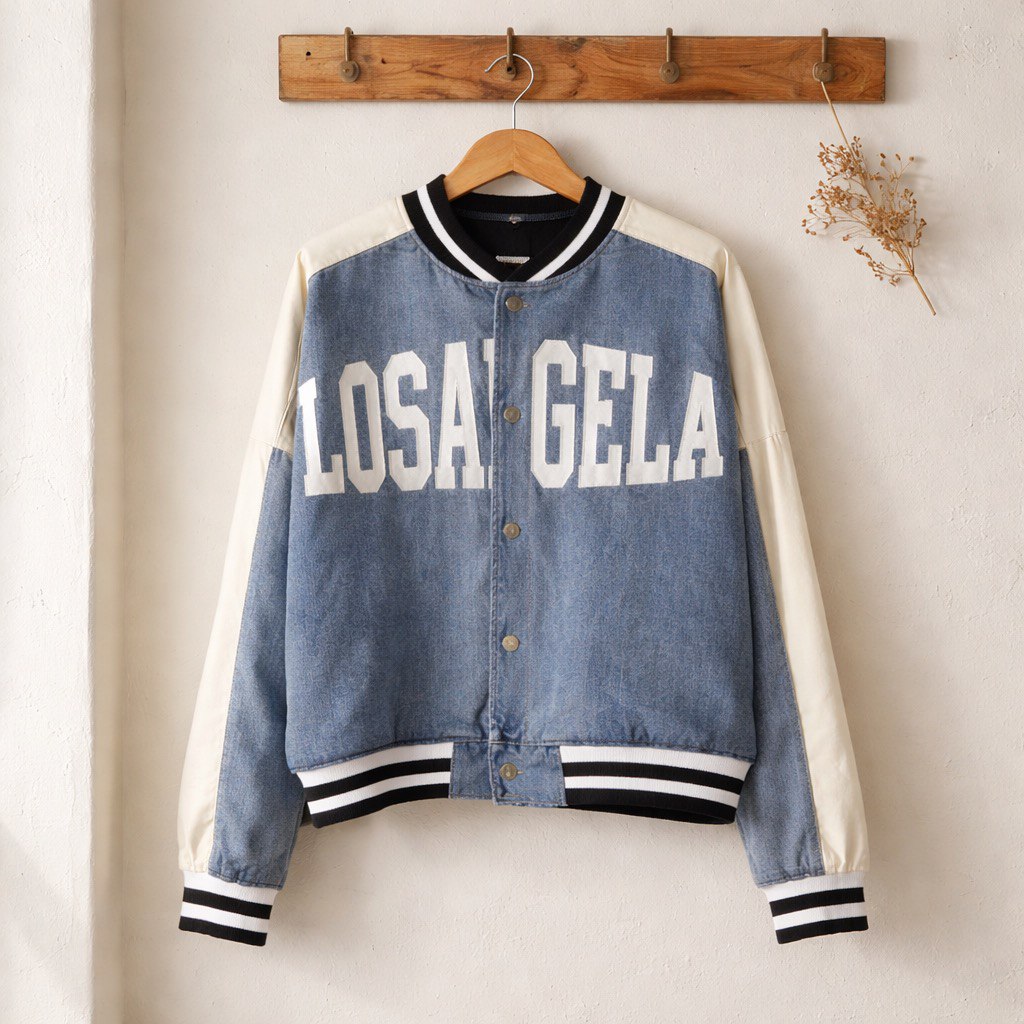 Giubbino stile college in denim, con scritta frontale, chiusura bottoni, maniche a contrasto e dettagli elasticizzati a righe