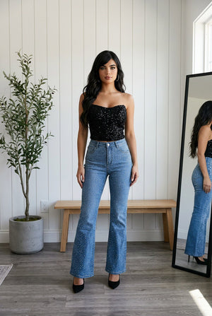 Jeans flare donna indossati  in denim chiaro high-waist con gamba a zampa e micro applicazioni brillanti