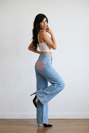Jeans palazzo in denim chiaro high-waist con fondo ampio e risvolto strutturato, tasche posteriori con applicazioni rosa brillanti