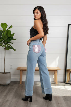 Jeans palazzo donna in denim chiaro high-waist con fondo ampio e risvolto strutturato, tasche posteriori con applicazioni rosa brillanti