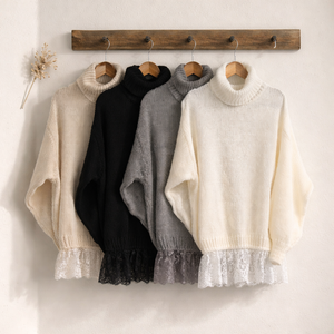 Vestito in maglia morbida bianco, grigio, beige o nero con maniche lunghe, collo avvolgente a coste e balza inferiore in pizzo